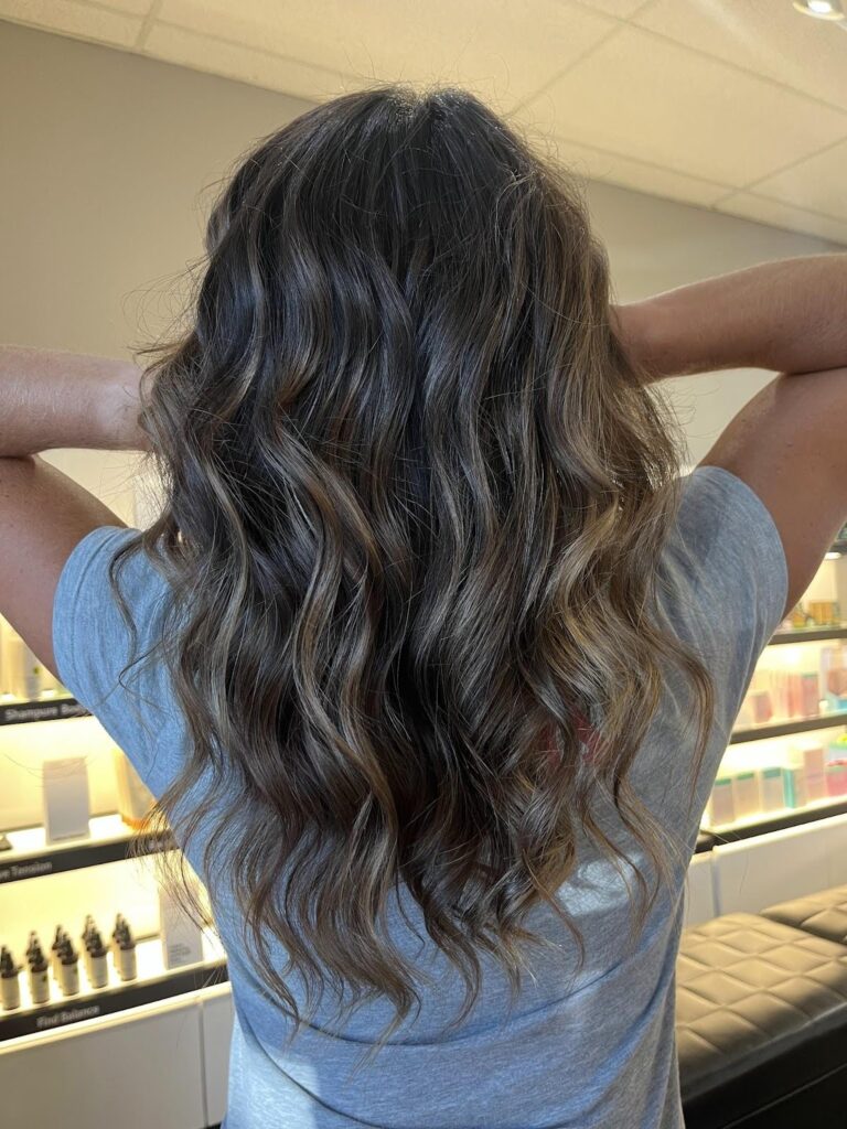 Wavy brunette hair with smoked suede fall balayage at a salon, showing soft dimension and natural-looking highlights. - Pure Salon Spa, KY.