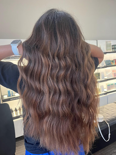 Long wavy hair with copper cashmere tones, featuring warm dimensional color and soft natural texture in a salon setting. - Pure Salon Spa, KY