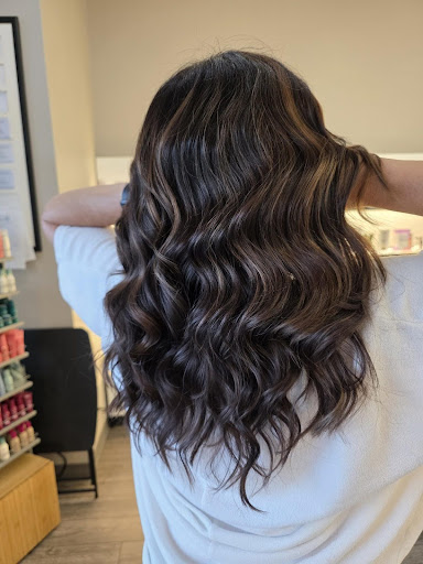 Wavy brunette hair with molten bronze highlights, featuring soft dimension and glossy curls in a salon setting. - Pure Salon Spa, KY