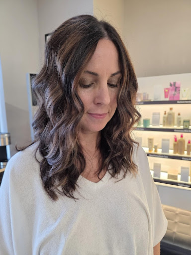 Long wavy brunette hair colored with molten bronze highlights, showing rich dimension and soft curls in a salon setting. - Pure Salon Spa, KY