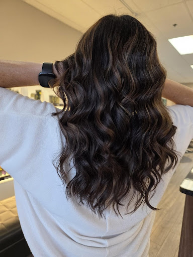 Molten bronze balayage on long wavy brunette hair, featuring warm dimensional highlights and soft flowing curls. - Pure Salon Spa, KY